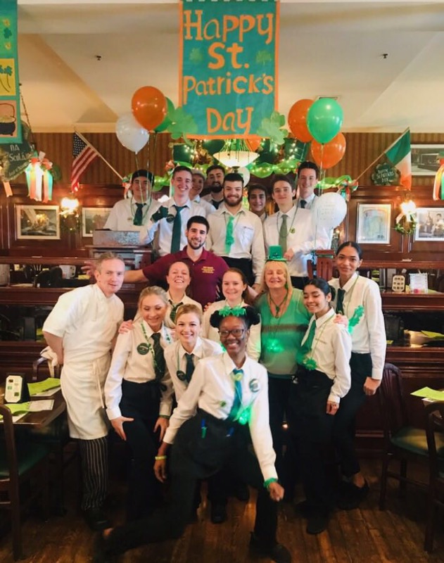 staff dressed in green hats